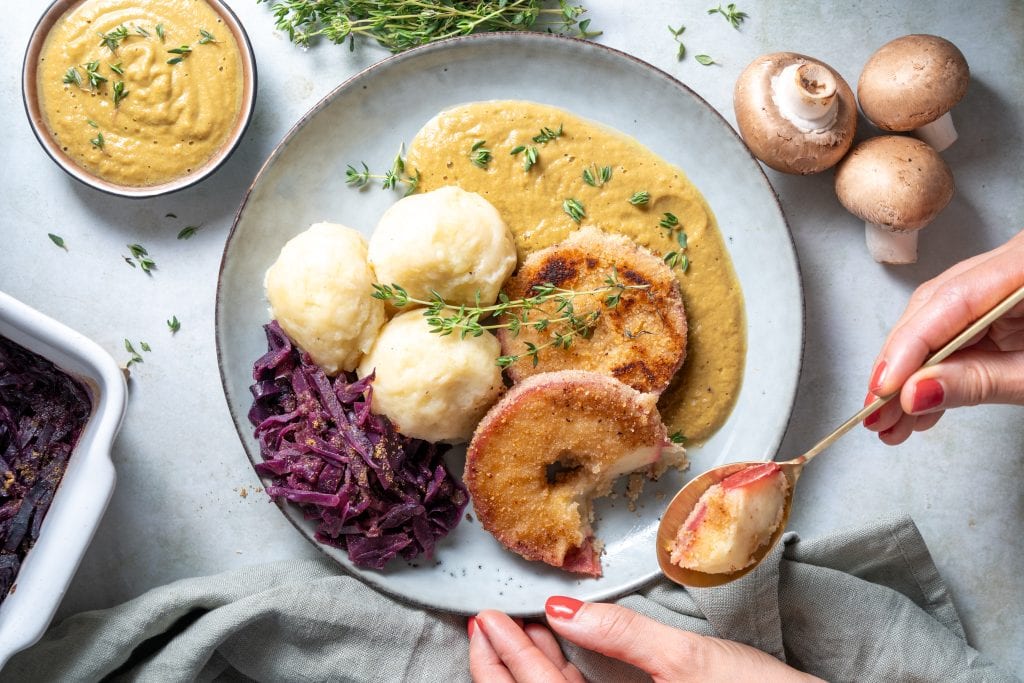 Trockenpflaumen Knoedel mit geschmortem Anis Rotkohl Ap felschnitzel und Sauce